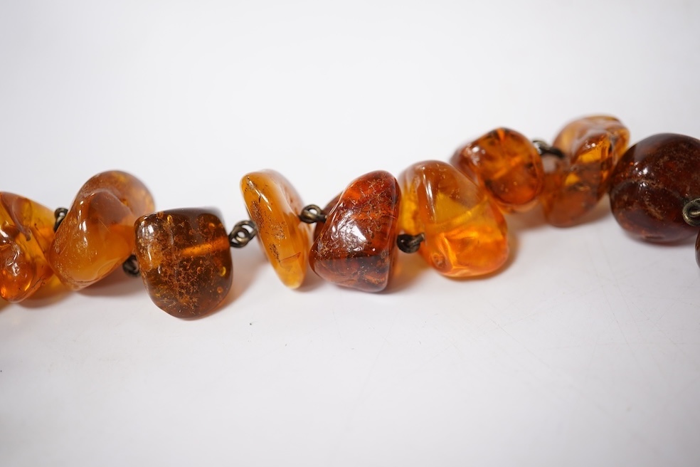 Three assorted amber necklaces including a single strand graduated oval bead necklace, 40cm, gross weight 37 grams, the other two necklaces gross weight 240 grams. Condition - poor to fair